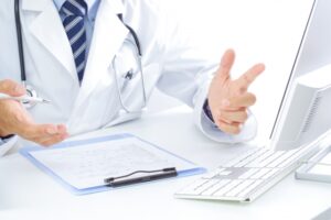 白衣の医師がデスクで説明する様子