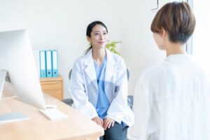 白衣の女性医師が患者と話している様子