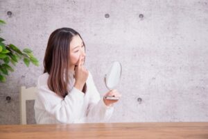 鏡で顔を確認する女性
