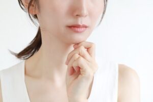 顎に手を当てて考える女性