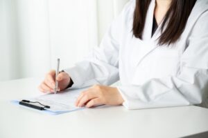 カルテに記入する医師