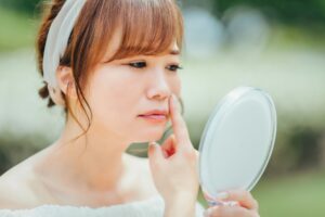 鏡で鼻を確認する女性