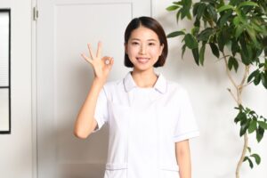 白い制服を着た女性がOKサイン