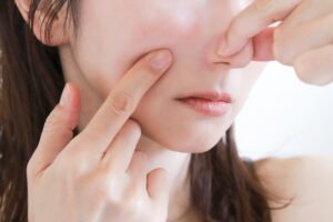 鼻をつまみむ女性