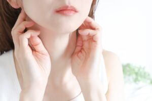 顎の下に触れる女性