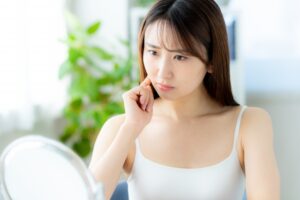 鏡を見て悩む女性
