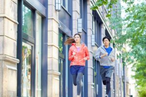 街中を走る男女のランナー