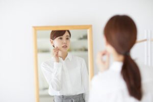 鏡で顔を確認する女性