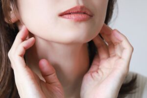女性が顎下に手を当てている様子