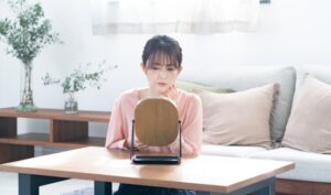 卓上の鏡を見る女性