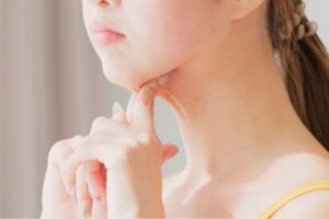 女性が首元のたるみを指でつまんでいる様子